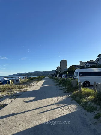 右が駐車場で左がビーチ&サイト